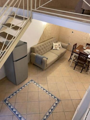 ein Wohnzimmer mit einem Sofa und einem Tisch in der Unterkunft Casa Catania Centro Il Bovio in Catania