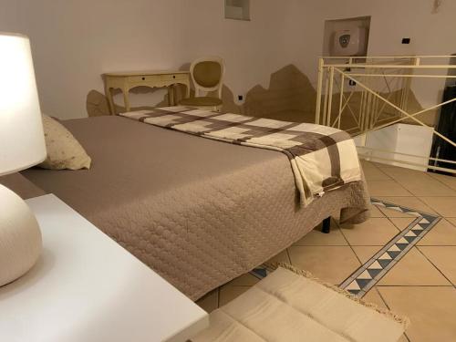 ein Schlafzimmer mit einem Bett und einem Tisch mit einer Lampe in der Unterkunft Casa Catania Centro Il Bovio in Catania