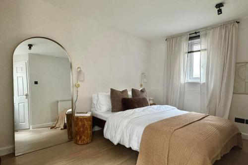 a bedroom with a large bed and a mirror at No.1 Lighthouse Dawlish Beach in Dawlish