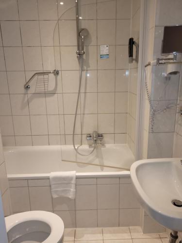 a bathroom with a shower and a toilet and a sink at Hotel Franken an der Messe in Frankfurt