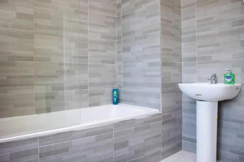 a bathroom with a bath tub and a sink at Charming 4BR House in Liverpool FC in Liverpool