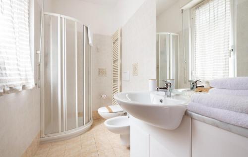 bagno bianco con lavandino e servizi igienici di Terrazza Panoramica a Oggebbio