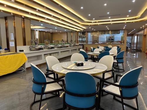 XI AN JIU DIAN Hotel في سيهانوكفيل: مطعم به كراسي وطاولات زرقاء وبيضاء
