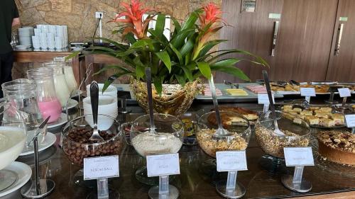 a buffet of desserts and pastries on a table at Hotel Varandas do Sol in Poços de Caldas