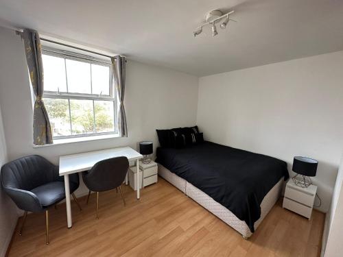 a bedroom with a bed and a desk and a window at Luxury Stay near London Eye zone 1 in London