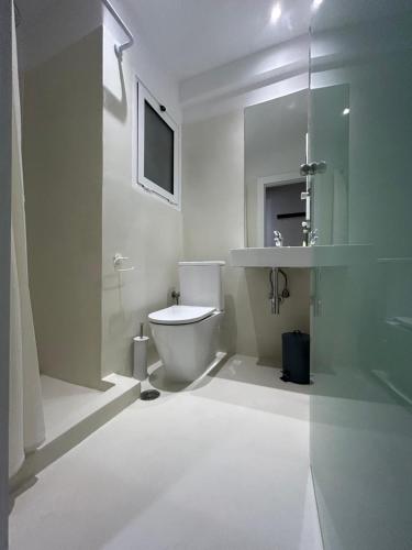 Platon Hotel في بيرايوس: حمام ابيض مع مرحاض ومغسلة