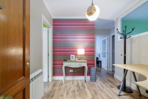 a room with a desk and a red striped wall at Con parking gratis en el centro by CABANA Rentals in Vigo
