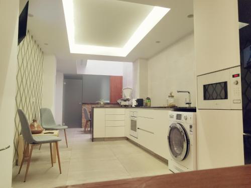 uma cozinha com uma máquina de lavar roupa e uma máquina de lavar roupa em Oasis de Valencia em Valência