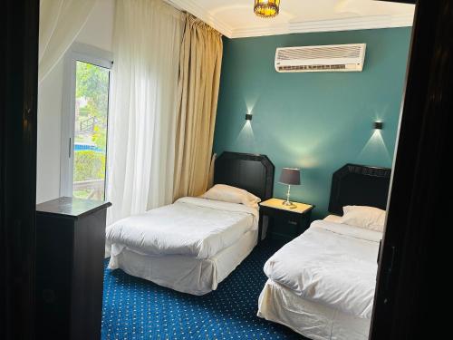 een hotelkamer met 2 bedden en een raam bij Private Luxury Villas at Sharm Dreams Resort in Sharm El Sheikh