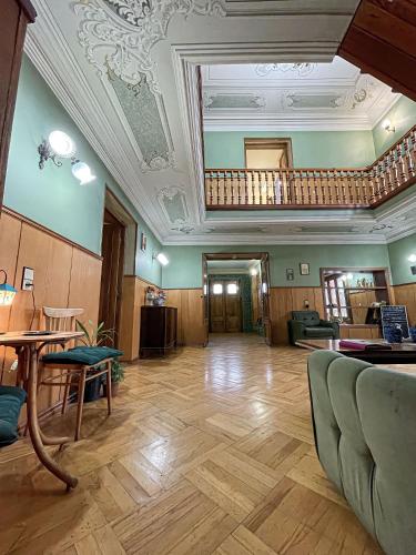 a large room with a ceiling with a table and chairs at Guest House Top Floor in Tʼelavi
