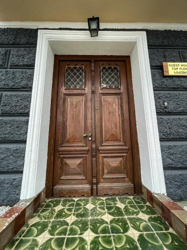 a wooden door on a house with a green floor at Guest House Top Floor in Tʼelavi