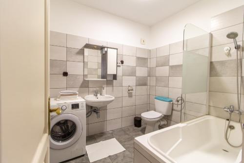 een badkamer met een wasmachine en een wastafel bij Déli Terasz C Apartman Free parking, self-check-in anytime in Győr