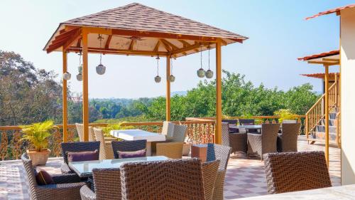 a patio with tables and chairs under a pavilion at 360 Bliss Dia Hotels in Nerul