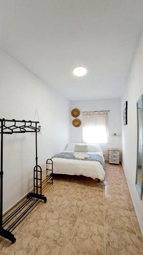 - une chambre blanche avec un lit et une fenêtre dans l'établissement La casita del arco, à Santa Cruz de la Zarza