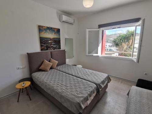a small bedroom with a bed and a window at VILLA VASILIS ORNOS in Mýkonos City