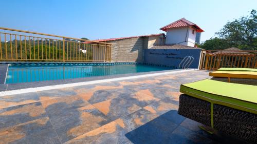 a swimming pool in a yard with a house at 360 Bliss Dia Hotels in Nerul