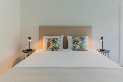 a bedroom with a white bed with two pillows at Primeiro Quartel Apartments - 4 in Peso da Régua