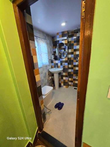 a bathroom with a toilet and a sink at Pharping Homestay in Dakshīnkāli