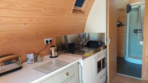 a kitchen with a stove and a counter top at Robin- Ensuite Glamping Pod in Truro