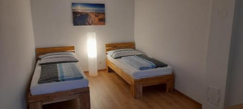 two twin beds in a room with a lamp at Landhaus ANDREA in Litzelsdorf