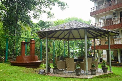 a gazebo with chairs and a fountain in a yard at 360 Bliss Dia Hotels in Nerul