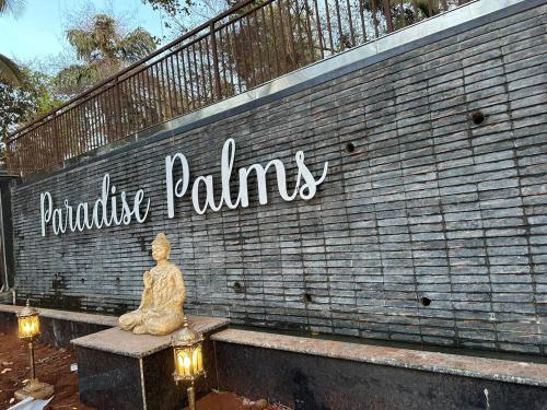 a statue sitting on a bench in front of a brick wall at 360 Bliss Dia Hotels in Nerul