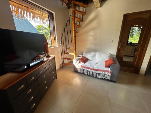 a living room with a chair and a flat screen tv at Wassaï Lodge in Matoury