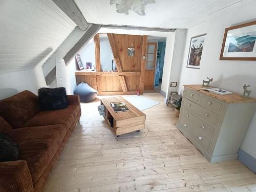 ein Wohnzimmer mit einem Sofa und einem Couchtisch in der Unterkunft Charmant meublé classé 3 étoiles dans ferme du XIXe restaurée in Le Hohwald
