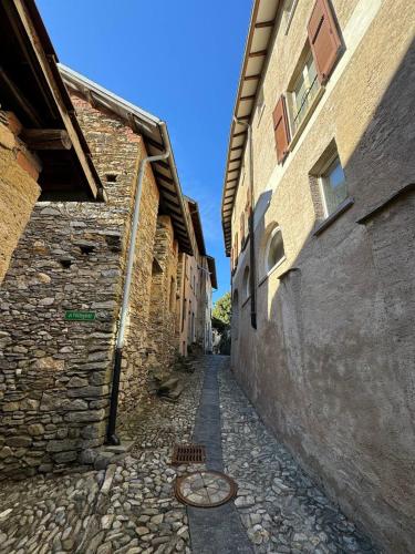 eine Gasse mit Gebäuden und einer Kopfsteinpflasterstraße in der Unterkunft Il borgo di Astano in Astano