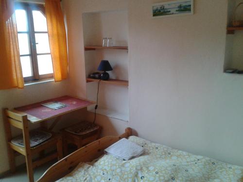 a bedroom with a bed and a desk and a window at Penzion U Vejvodu in Třeboň