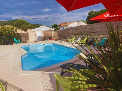 una piscina con sillas y una sombrilla roja en Hotel Restaurant Les Chataigniers, en Privas