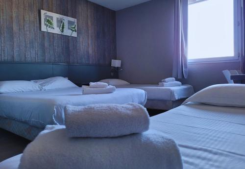 En eller flere senge i et værelse på Hotel Restaurant Les Chataigniers