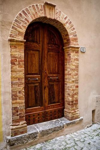uma grande porta de madeira num edifício de tijolos em Maison Camilla Casa vacanze em Monte San Biagio