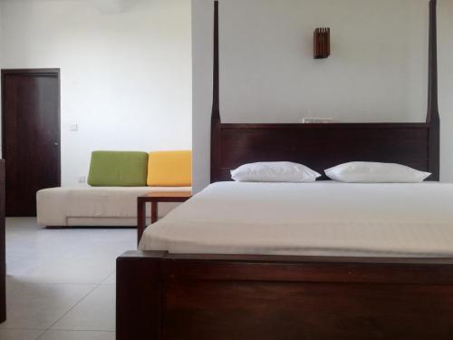 1 dormitorio con 1 cama y 1 sofá en VILLA MAANE by GOODWILL en Hikkaduwa
