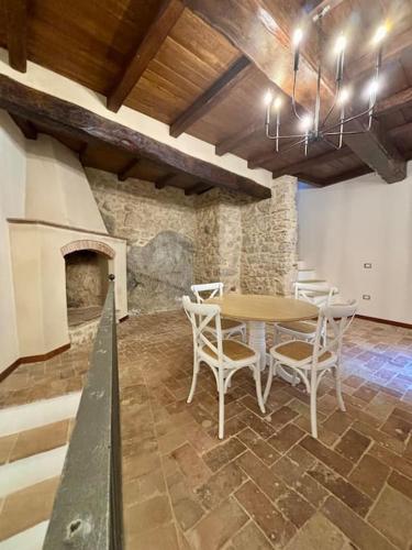 uma sala de jantar com uma mesa e cadeiras e uma lareira em Maison Camilla Casa vacanze em Monte San Biagio