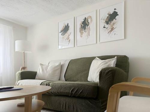 a living room with a green couch and a table at Private guest house - Double bedroom, en-suite and workspace with private entrance, first floor with no lift and no full kitchen in Leicester
