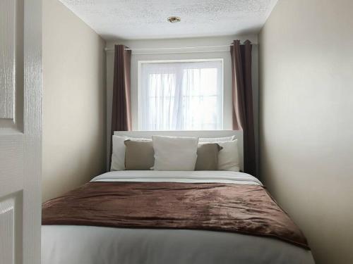 a bed in a small room with a window at Private guest house - Double bedroom, en-suite and workspace with private entrance, first floor with no lift and no full kitchen in Leicester