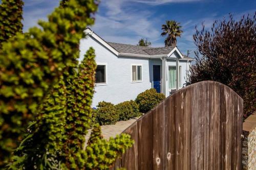 a white house with a fence in front of it at Family Friendly Home in Seaside