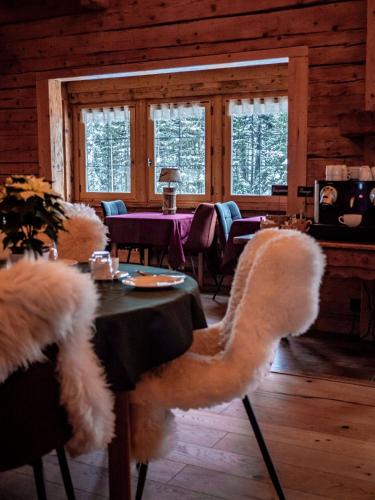 ラ・クリュサにあるLes Chalets de la Serrazのテーブルと毛皮の椅子のあるダイニングルーム