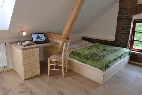 Schlafzimmer mit einem Bett und einem Schreibtisch mit einem Laptop in der Unterkunft Yogashrama traditional in Ústí nad Orlicí