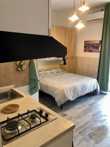 a kitchen with a stove top oven next to a bed at Appartamento Verona in Verona