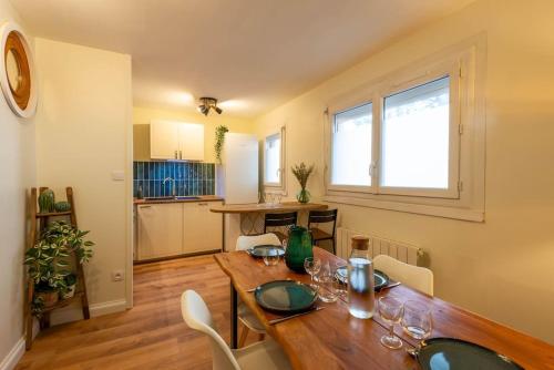 - une salle à manger avec une table en bois et des verres à vin dans l'établissement Balnéo & Sauna, séjour détente aux Teinturiers - Métro Charpennes - Garage, à Villeurbanne