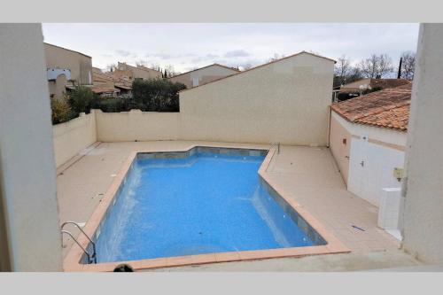 - une grande piscine bleue au-dessus d'une maison dans l'établissement LAVANDINES II Joli T3 mezzanine villa mitoyenne piscine proche plage Rochelongue Cap d'Agde, au Cap d'Agde