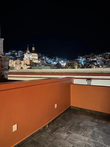 a room with a view of a city at night at Suites del Jardín Principal in Guanajuato
