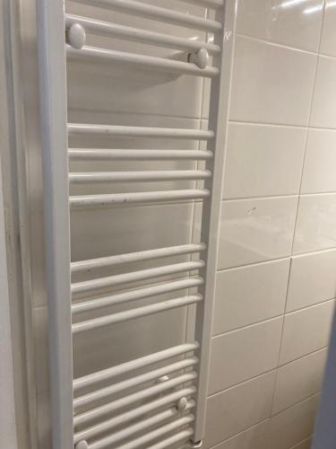d'un placard avec des étagères blanches dans la salle de bains. dans l'établissement Modhumita, à Chambéry