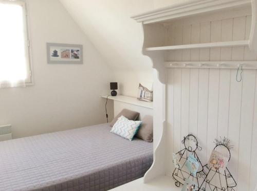 - une chambre blanche avec un lit et une étagère dans l'établissement 752 - Maison avec jardin à 2km du centre d'Erquy des commerces et des plages sauvages, à Erquy