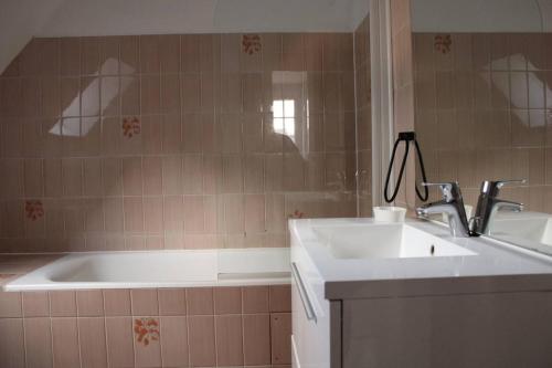 une salle de bain avec un lavabo et une baignoire dans l'établissement 752 - Maison avec jardin à 2km du centre d'Erquy des commerces et des plages sauvages, à Erquy
