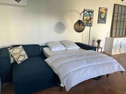 - un lit dans une chambre avec un canapé bleu dans l'établissement Une halte entre terre et mer, à Espira-de-lʼAgly