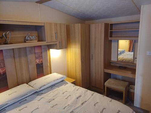 een kleine slaapkamer met een bed en een spiegel bij The Highlander in Tain