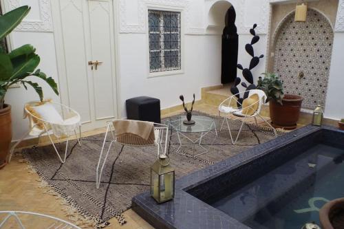 - un salon avec des chaises et une piscine dans l'établissement Riad rénové en 2023, idéalement situé, 5 minutes de la place Jemaa El Fna, à Marrakech